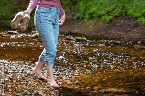 Woman Walking Barefoot In Mountain River. Finnich Glen.The Devil’s Pulpit in Scotland. UK. 