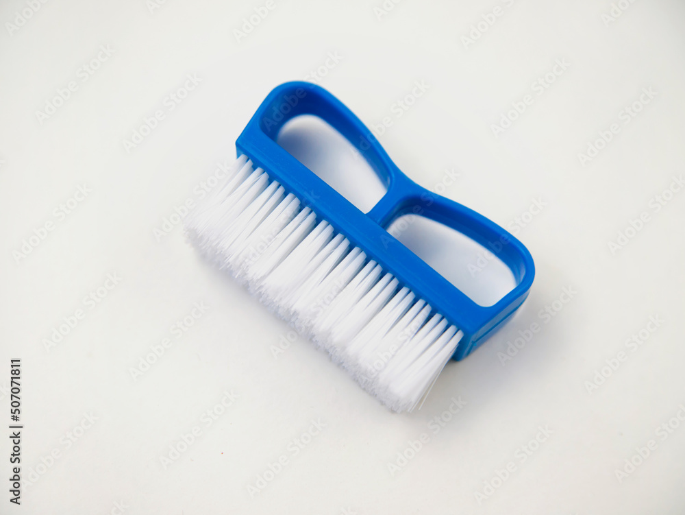 Close-up, cleaning brush on a white background. A brush with a white pile and a blue handle. Convenient equipment for cleaning the house. Close-up, cleaning brush on a white background. A brush with a white pile and a blue handle. Convenient equipment for cleaning the house.