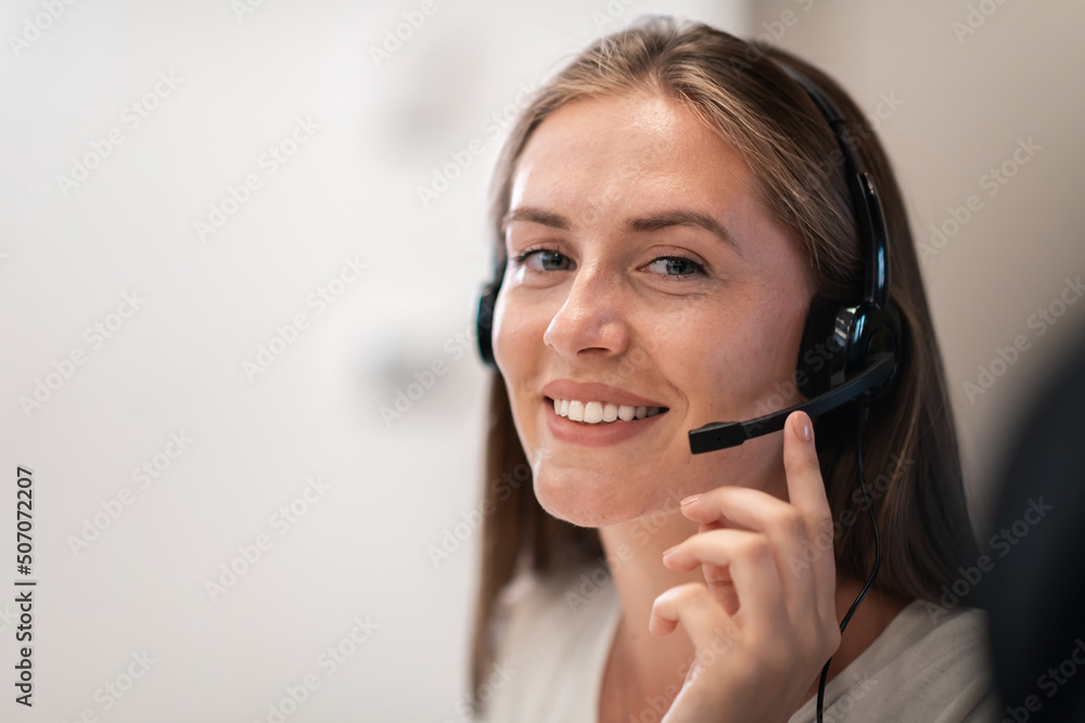 Helpline female operator with headphones in call centre.Business woman with headsets working in a call center. Selective focus Helpline female operator with headphones in call centre.Business woman with headsets working in a call center. Selective focus