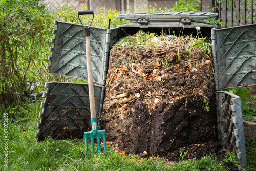 Layers of rotting compost in plastic composter bin in garden photo
