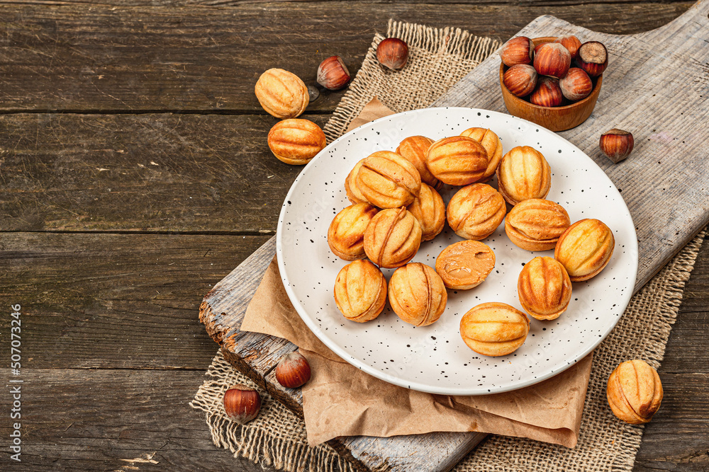 Fototapeta premium Cookies in the shape of walnuts with condensed milk cream filling.Delicious shortbread sandwiches