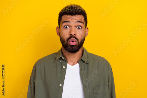 Photo of shocked pretty guy dressed green shirt big eyes isolated yellow color background