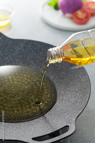 pouring vegetable oil to a frying pan.