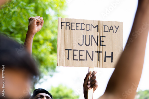 Fototapeta concept of Juneteenth freedom day march showing by close up protesting hands sig
