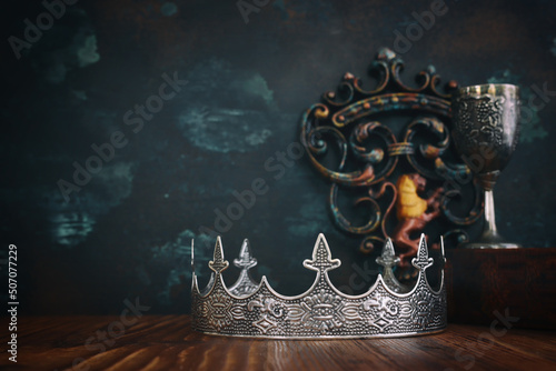 low key image of beautiful queen or king crown and old book. fantasy medieval period