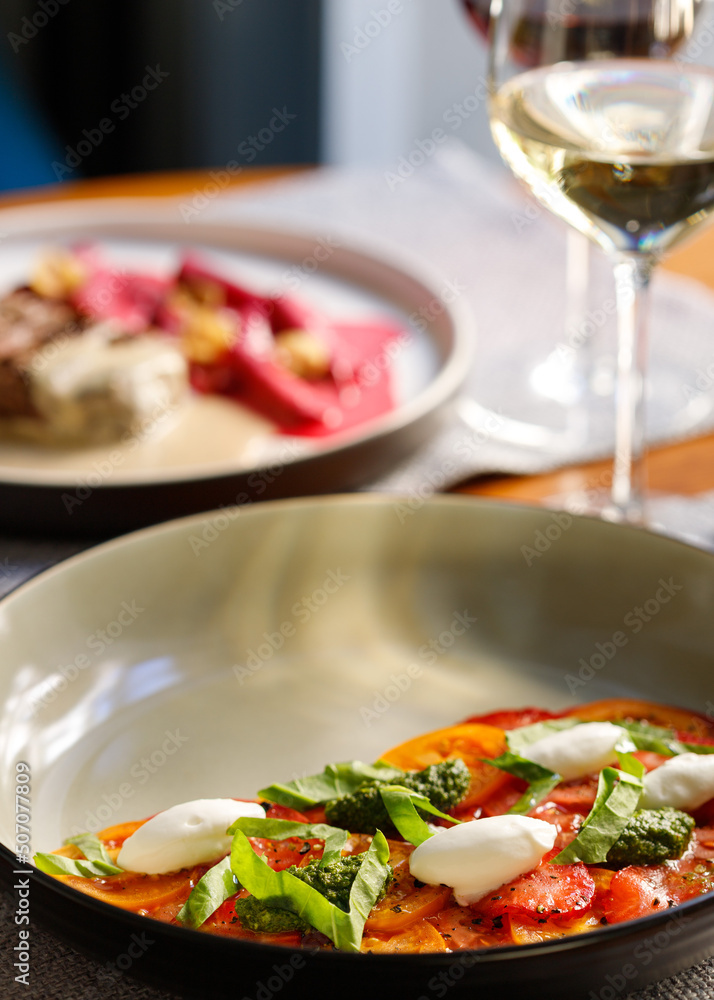Lunch at the restaurant. Salad and a glass of wine. Selective focus, close-up Lunch at the restaurant. Salad and a glass of wine. Selective focus, close-up