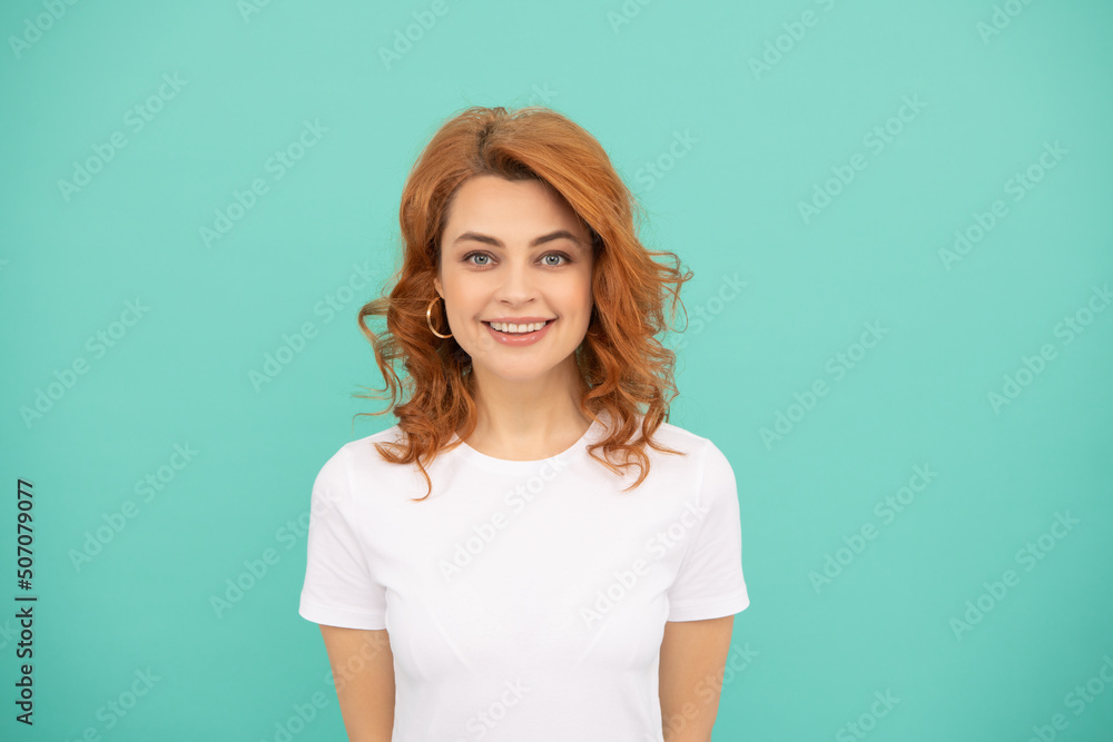 positive redhead woman with curly hair on blue background positive redhead woman with curly hair on blue background