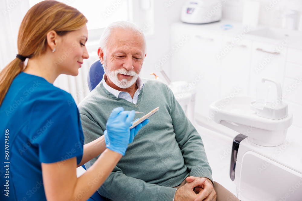 Dentist showing dentail facets color palette to patient Dentist showing dentail facets color palette to patient