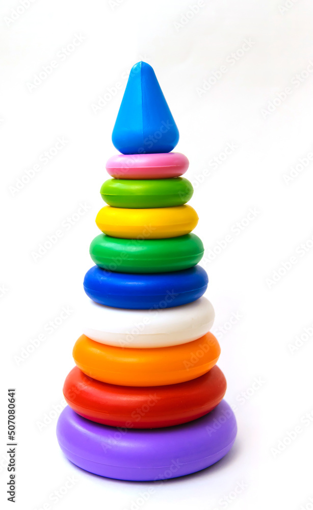 Children's plastic toy, a pyramid of colored rings on a white background. Development and education of the child. Children's plastic toy, a pyramid of colored rings on a white background. Development and education of the child.