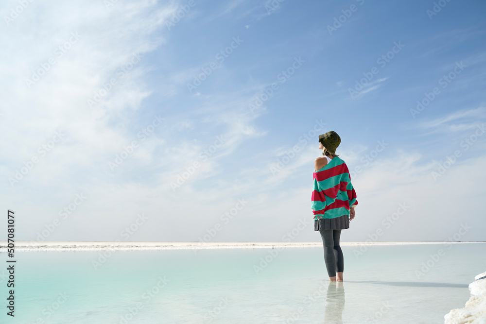 asian female tourist standing in water of a salt lake