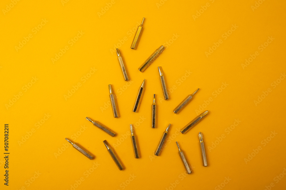 Small screwdriver bits on a yellow background Small screwdriver bits on a yellow background
