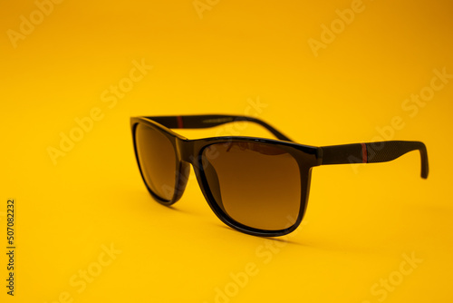 Black s sunglasses on orange background