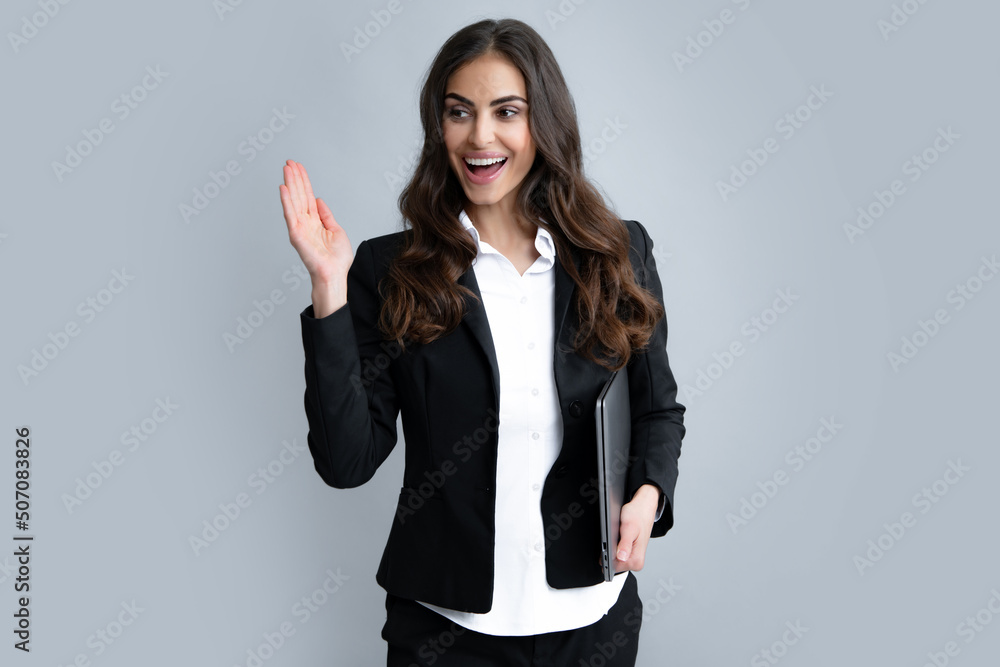 Beautiful smiling business woman over grey background using laptop computer. Beautiful smiling business woman over grey background using laptop computer.