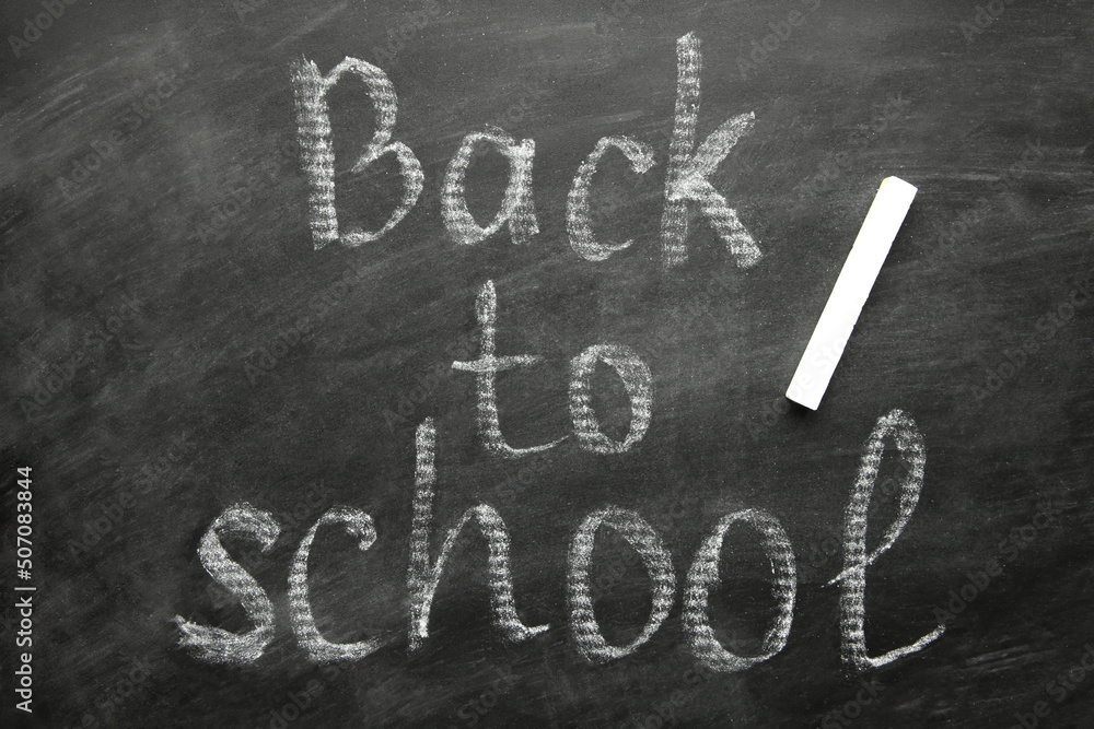 Fototapeta premium Inscription back to school on blackboard on green background. Concept - a new academic year