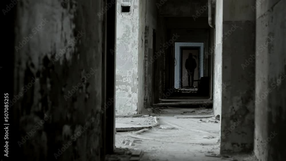 Abandoned corridor of the building and the man in it. Danger and horror in dangerous places. Abandoned corridor of the building and the man in it. Danger and horror in dangerous places.