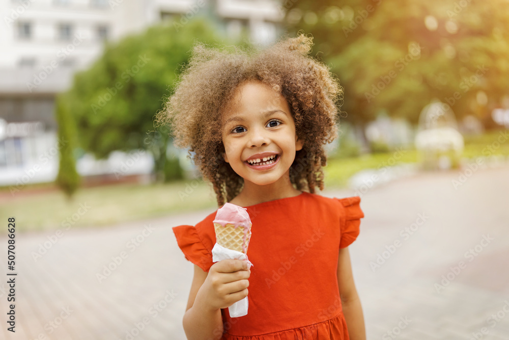 a black child eats ice cream in a waffle cone at a summer day a black child eats ice cream in a waffle cone at a summer day