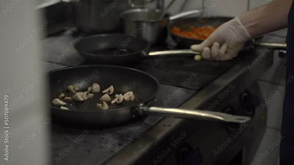 cook frying mushrooms in a frying pan cook frying mushrooms in a frying pan