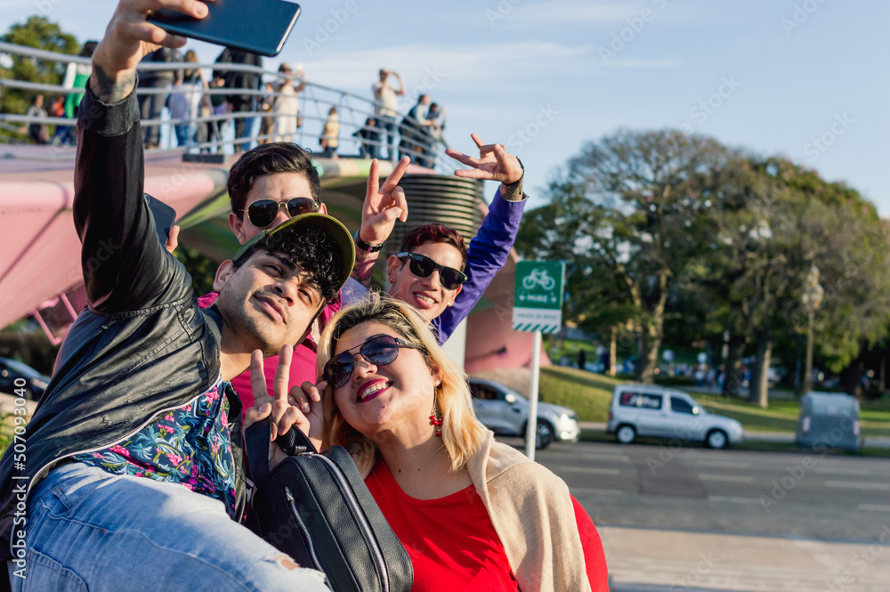 Obraz premium group of friend on the street standing smiling taking a selfie with the phone, copy space.