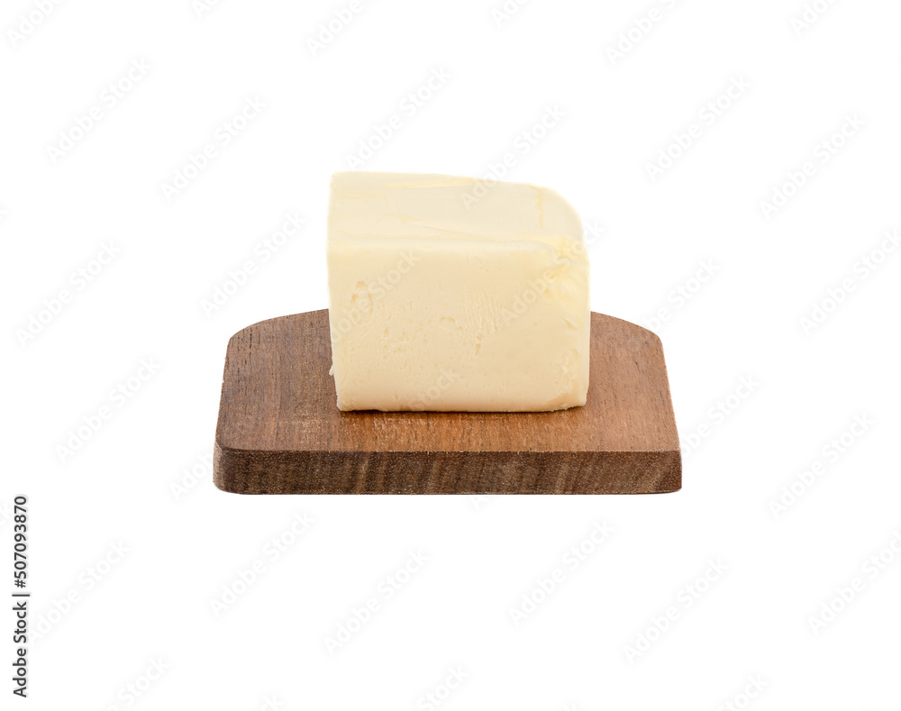 A piece of butter on a wooden board over a white background. A piece of butter on a wooden board over a white background.