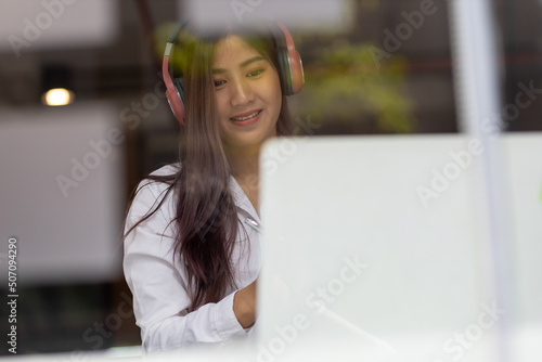 Business woman working with laptop in glass office.