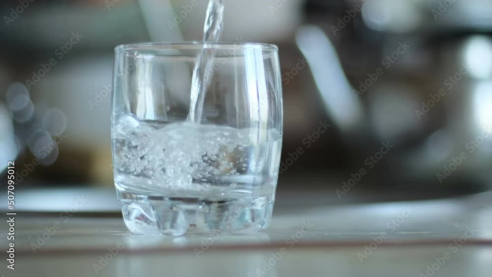 Pure transparent drinking water is poured into a glass beaker close-up Pure transparent drinking water is poured into a glass beaker close-up
