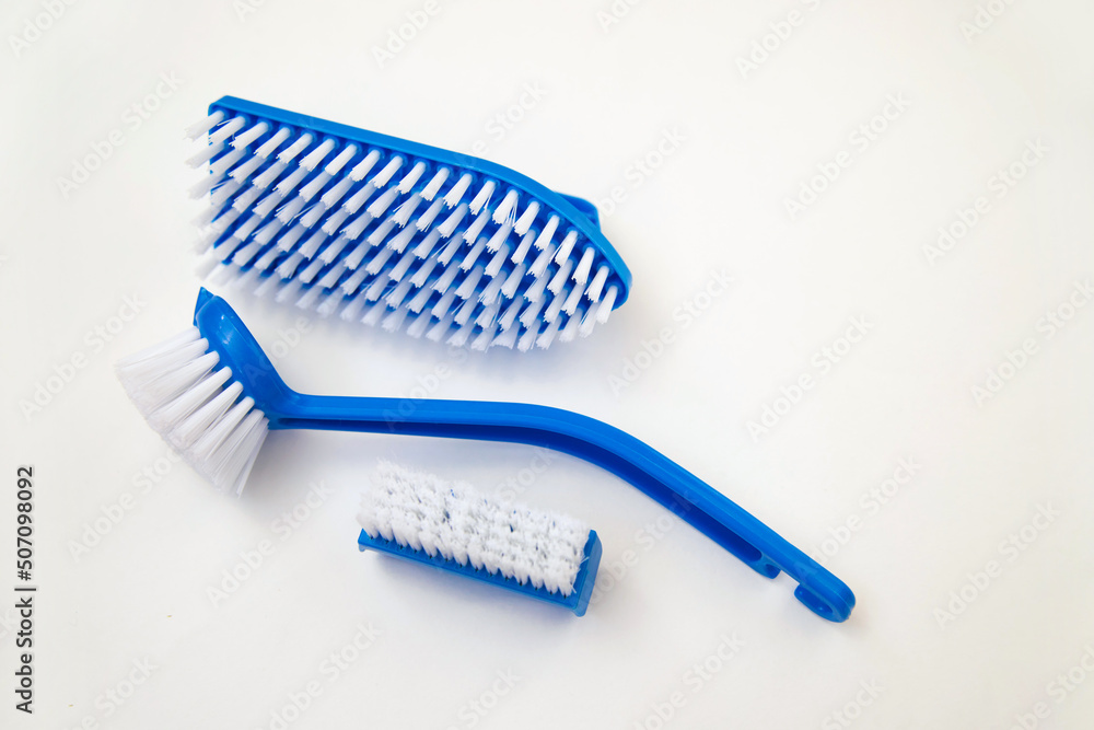 Close-up, cleaning brush on a white background. A brush with a white pile and a blue handle. Convenient equipment for cleaning the house. Close-up, cleaning brush on a white background. A brush with a white pile and a blue handle. Convenient equipment for cleaning the house.