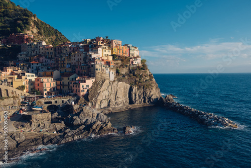 Beautiful view of rocky hills and colorful historic buildings of Manarola  tourist attraction and famous place in Liguria  Italy. Hillside over the sea at sunset.