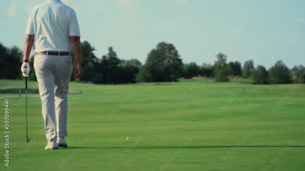 Professional athlete playing golf outdoors. Man walking golfing course in summer Professional athlete playing golf outdoors. Man walking golfing course in summer