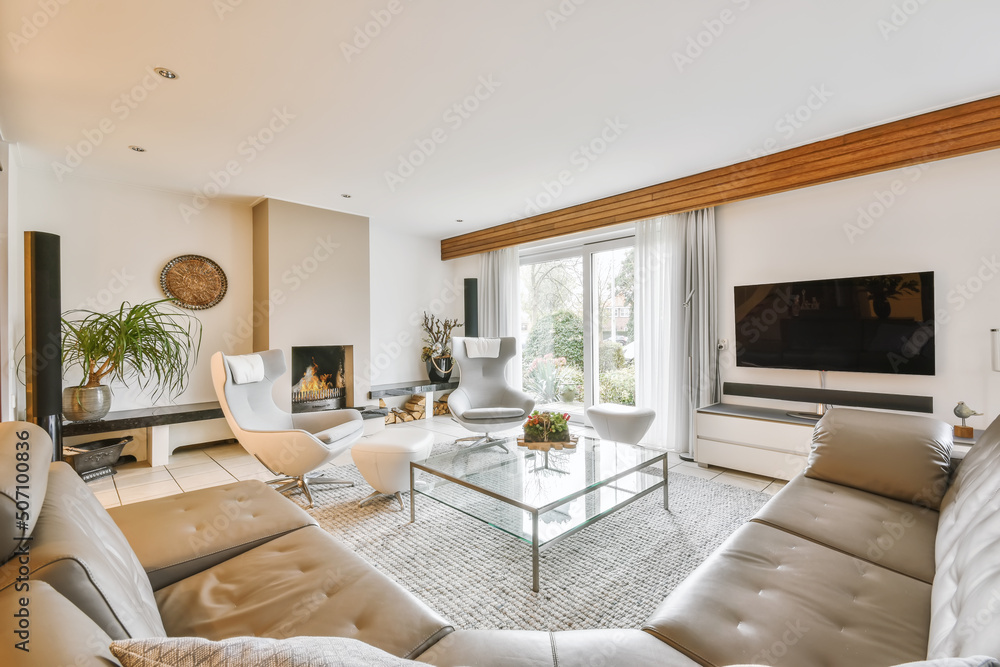 Interior of modern living room with cozy couch and armchairs near fireplace Interior of modern living room with cozy couch and armchairs near fireplace