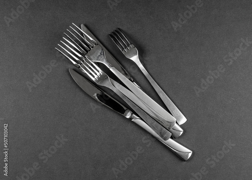 Lots of cutlery on black table, abstract food background