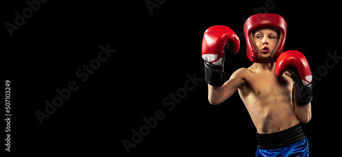 Flyer with sportive boy, kid in boxer gloves and shorts practicing isolated on dark background. Concept of sport, movement, studying, achievements, active lifestyle.
