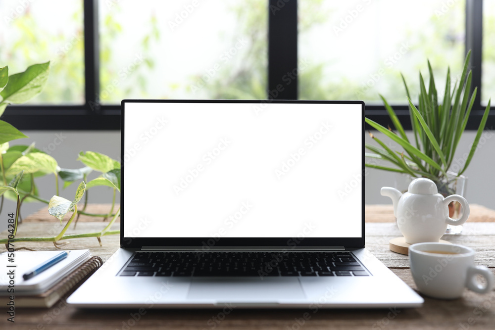 Laptop and plant pot on wooden table Laptop and plant pot on wooden table