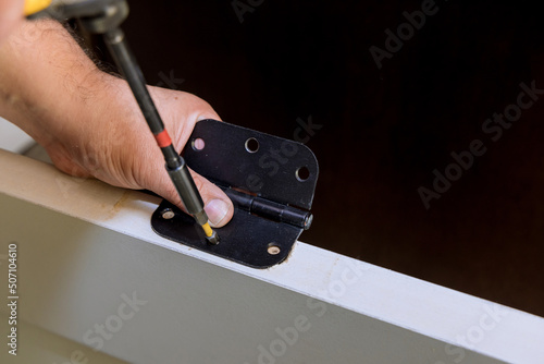 Man installing stainless door hinges for interior
