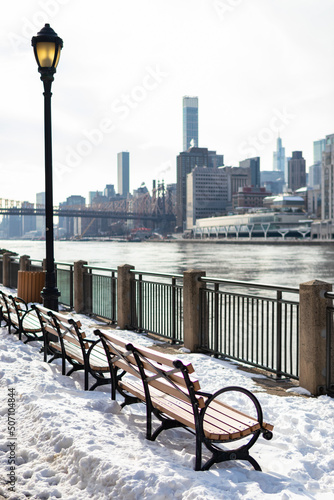 Canvas Print Empty Wood Benches on Roosevelt Island in New York City with Snow during the Win