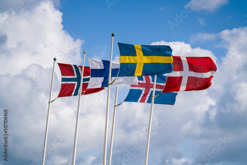 Scandinavian flags waving against cloudy sky. Selective focus.