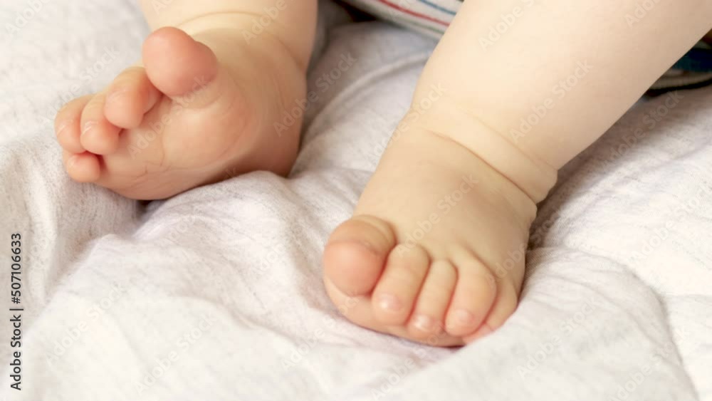 cute little baby feets lying on bed, white blanket. toddler moving gentle feet fingers. motherhood, baby care concept. macro shot of child's leg,toes, 4 k video cute little baby feets lying on bed, white blanket. toddler moving gentle feet fingers. motherhood, baby care concept. macro shot of child's leg,toes, 4 k video