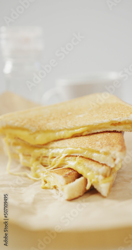 Vertical image of close up of fresh toast with melted cheese on grey background