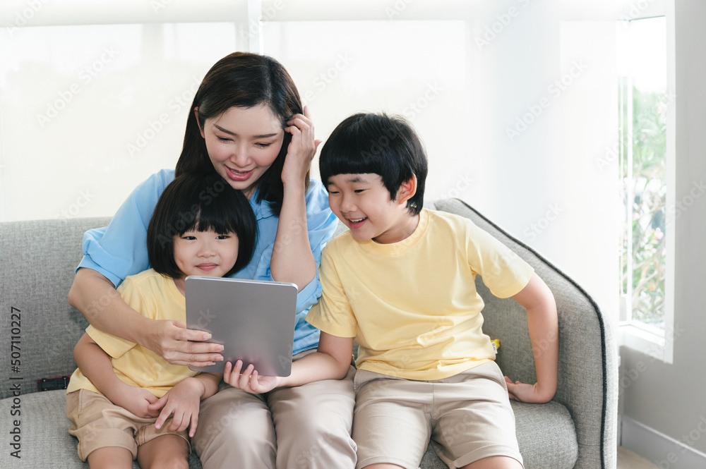 Fototapeta premium Happy Asia mother use tablet with sons at home 