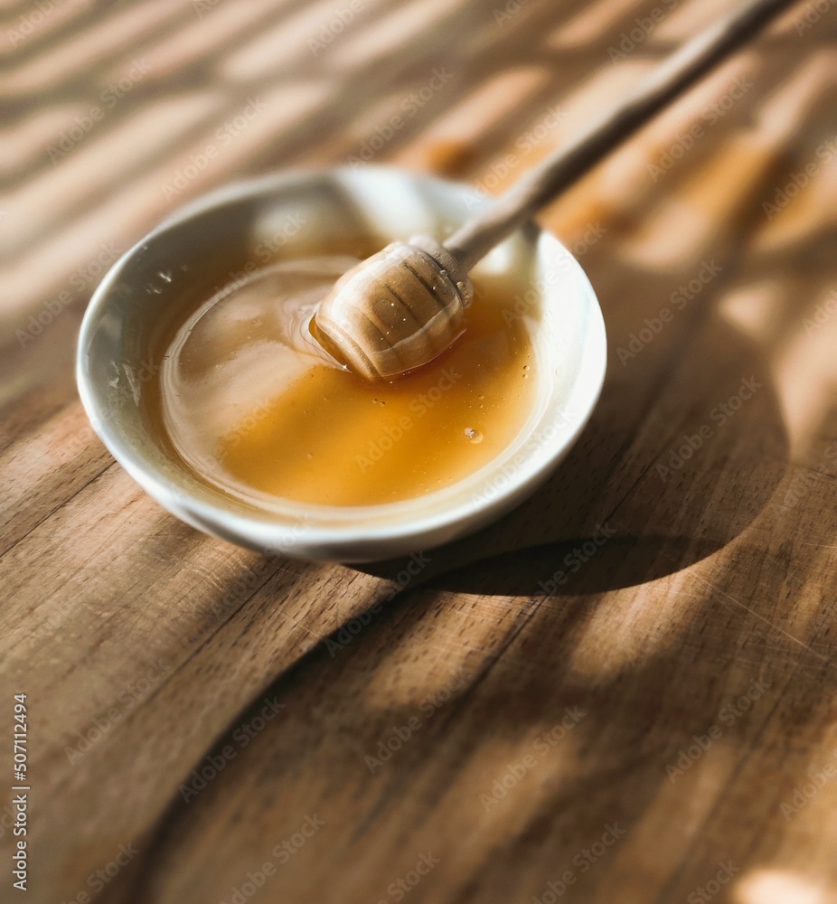 honey dripping from a wooden spoon honey dripping from a wooden spoon