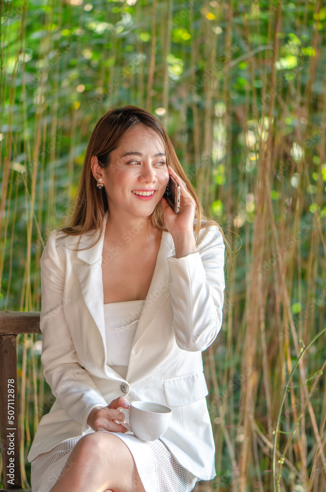 beautiful asian business woman use smart phone with drink coffee,happy and smile beautiful asian business woman use smart phone with drink coffee,happy and smile