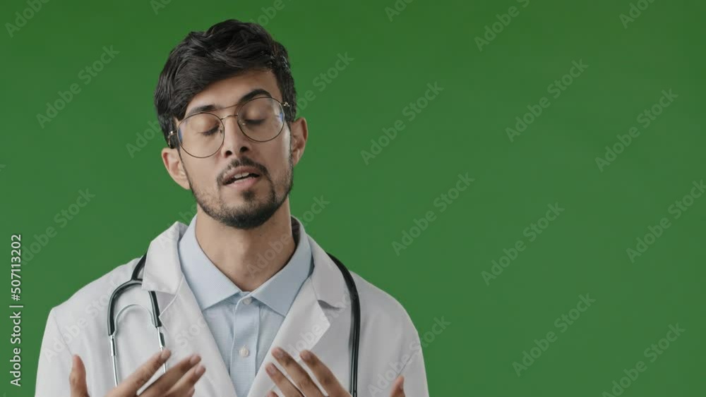 Young arabian male doctor man physician in white medical uniform on green background consult remote patient looking at web camera virtual video chat recommend medication treatment distant telemedicine Young arabian male doctor man physician in white medical uniform on green background consult remote patient looking at web camera virtual video chat recommend medication treatment distant telemedicine