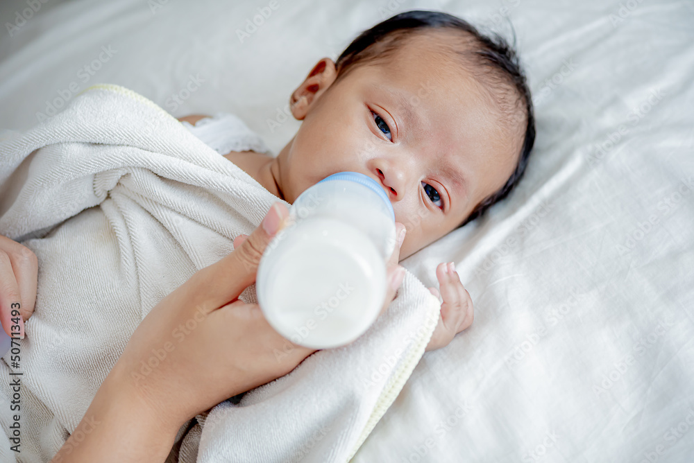 baby consumes milk from bottle fed by mother baby consumes milk from bottle fed by mother