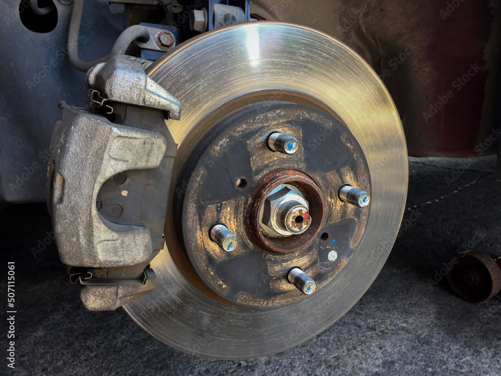 Close-up of the vehicle's disc brake in the garage for maintenance. Repairing the car's disc brake.