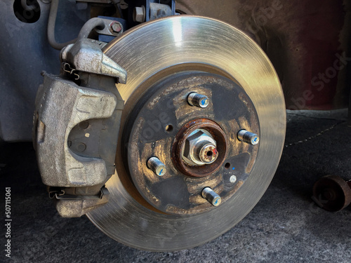 Close-up of the vehicle's disc brake in the garage for maintenance. Repairing the car's disc brake.