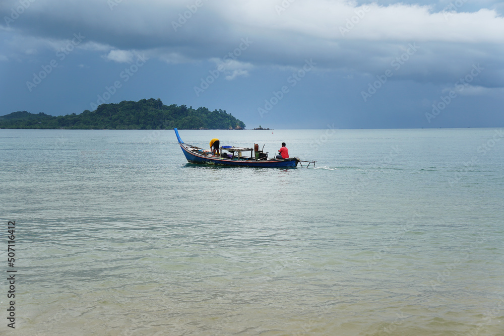 Local Asian fisherman boat on the sea with low floating clouds.