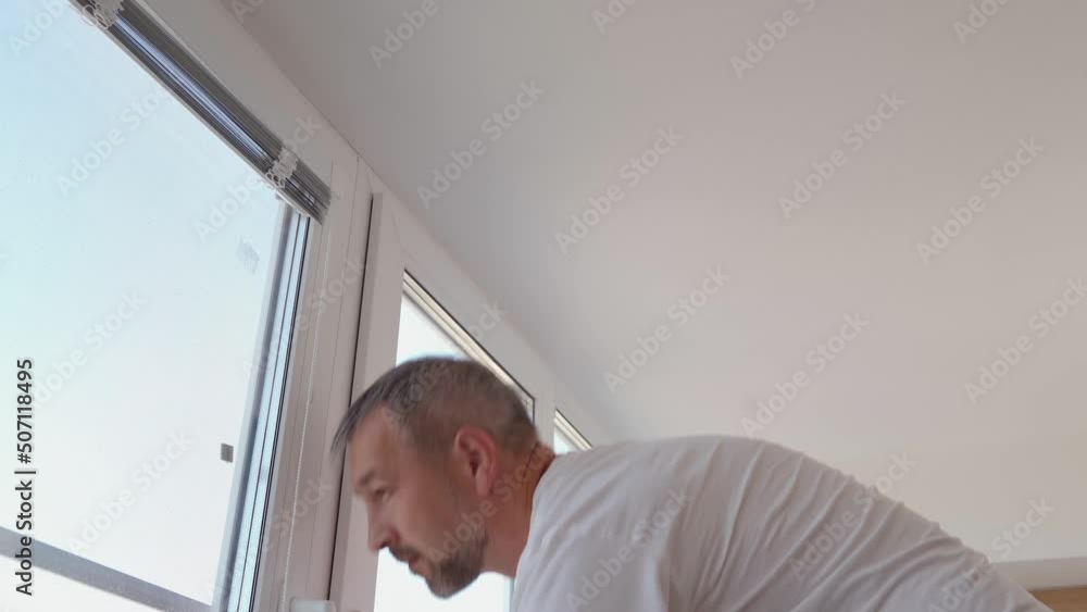 The man is drilling a hole in the window. Blinds installation. The man is drilling a hole in the window. Blinds installation.