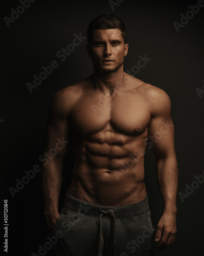 Shirtless sexy muscled male model standing in studio