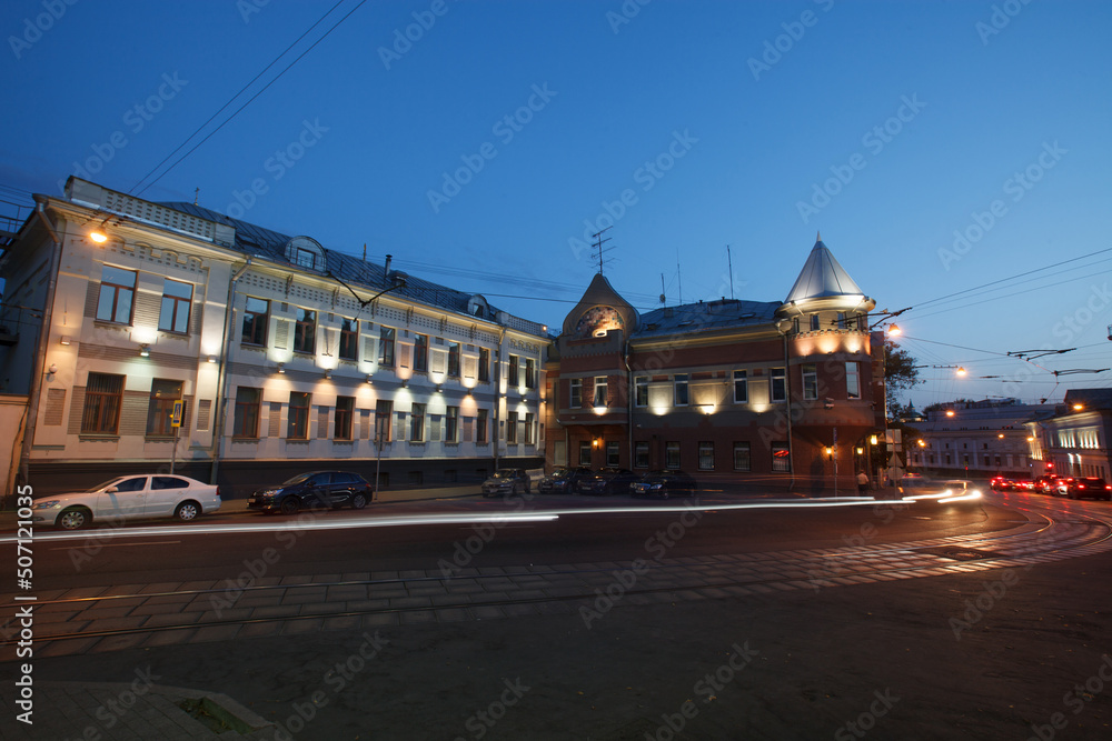 Naklejka premium Moscow, Russia - July, 27 2014: Historical buildings in Moscow center at night. Mansion on Yauza boulevard. Tram rails and light traces on foreground.