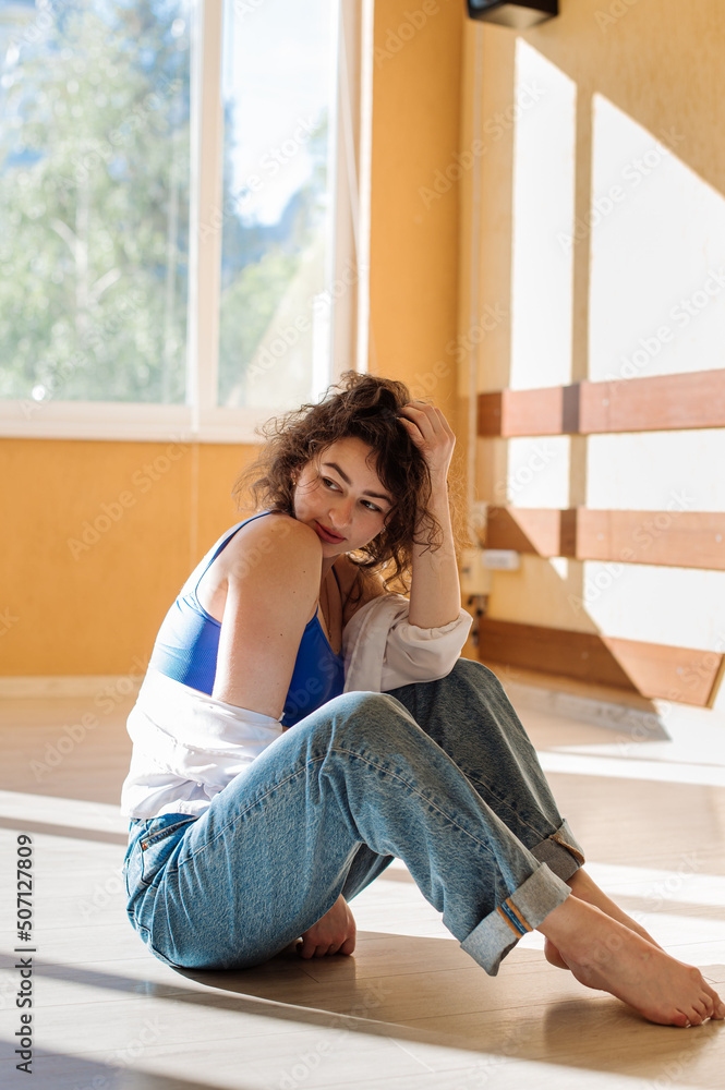 Dancer young girl in casual clothes dancing contemporary dance indoors the hall in morning sun lights Dancer young girl in casual clothes dancing contemporary dance indoors the hall in morning sun lights