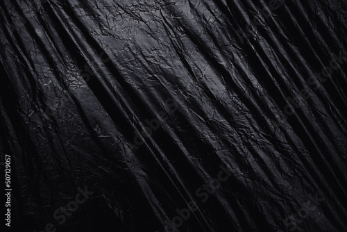 a transparent stretch plastic wrap on black background. realistic plastic wrap texture for overlay and effect. wrinkled plastic pattern for creative and decorative design.